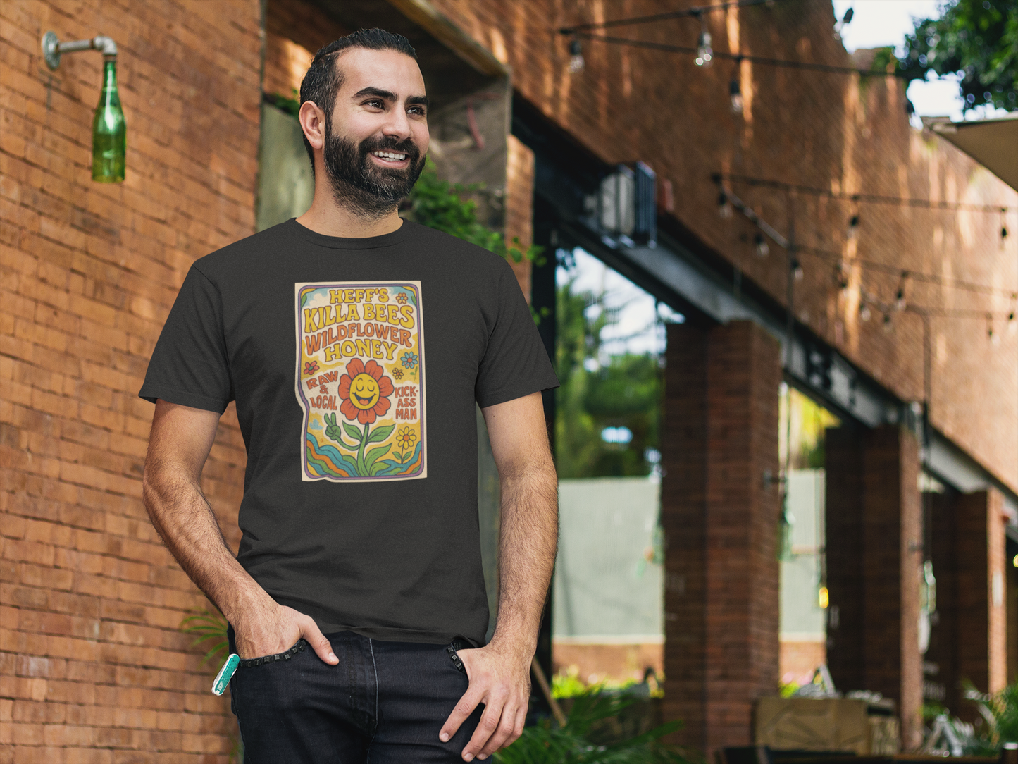 Man wearing a black t-shirt with a colorful graphic design outdoors.