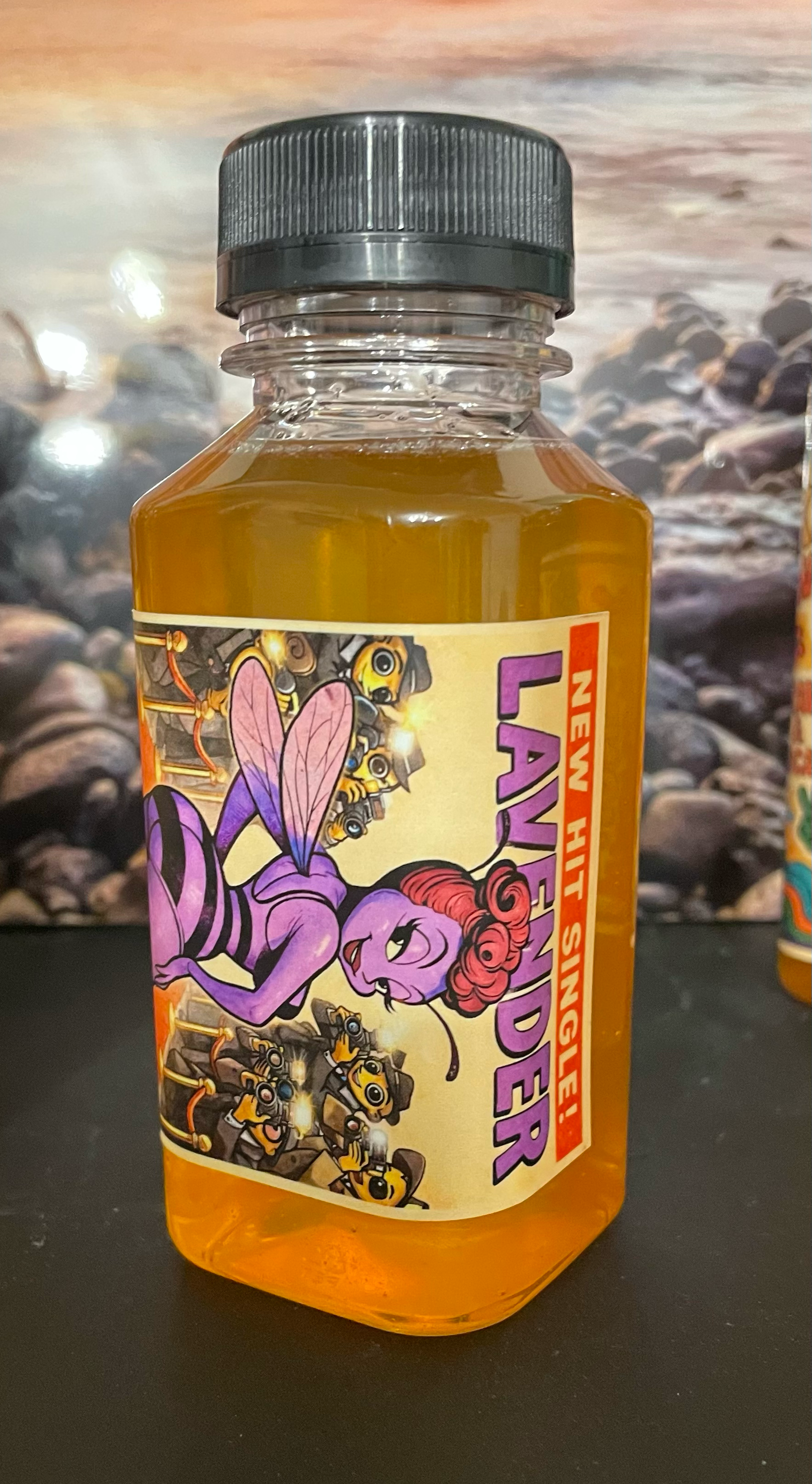 Bottle of Heff's Killa Bees lavender-flavored honey with a colorful label featuring cartoon characters on a dark surface.